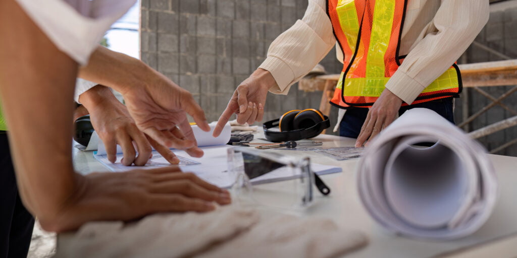 Construction concept of Engineer or architect meeting for project working with partner and engineering tools on building and blueprint in working site